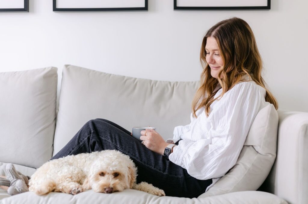 The Perfectionism Therapist, Natalie Englander, a woman sat with her dog reflecting on her guide for perfectionists about how to build lasting self-worth.