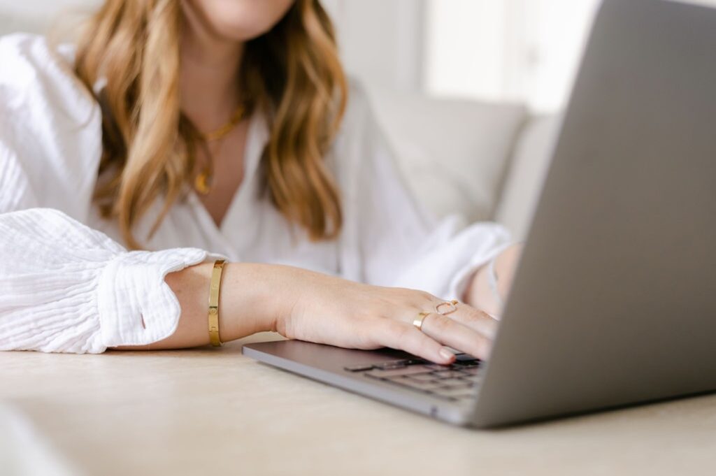 The Perfectionism Therapist, Natalie Englander, a woman typing on her laptop about how to spot unhealthy perfectionism.